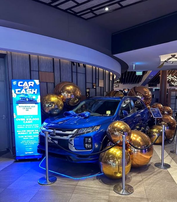 Car or Cash major prize promotion display with vehicle and gold spheres
