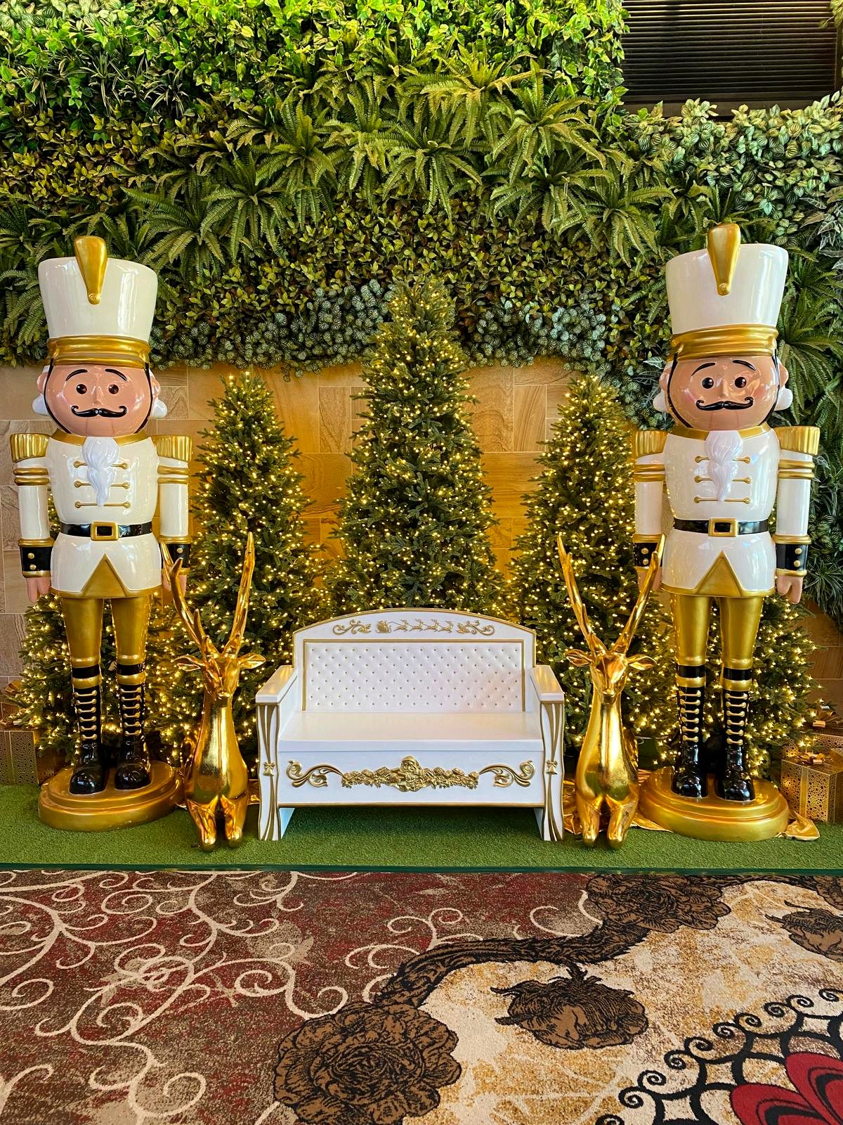 Nutcracker soldiers with gold gazelle statues and a Christmas photo bench