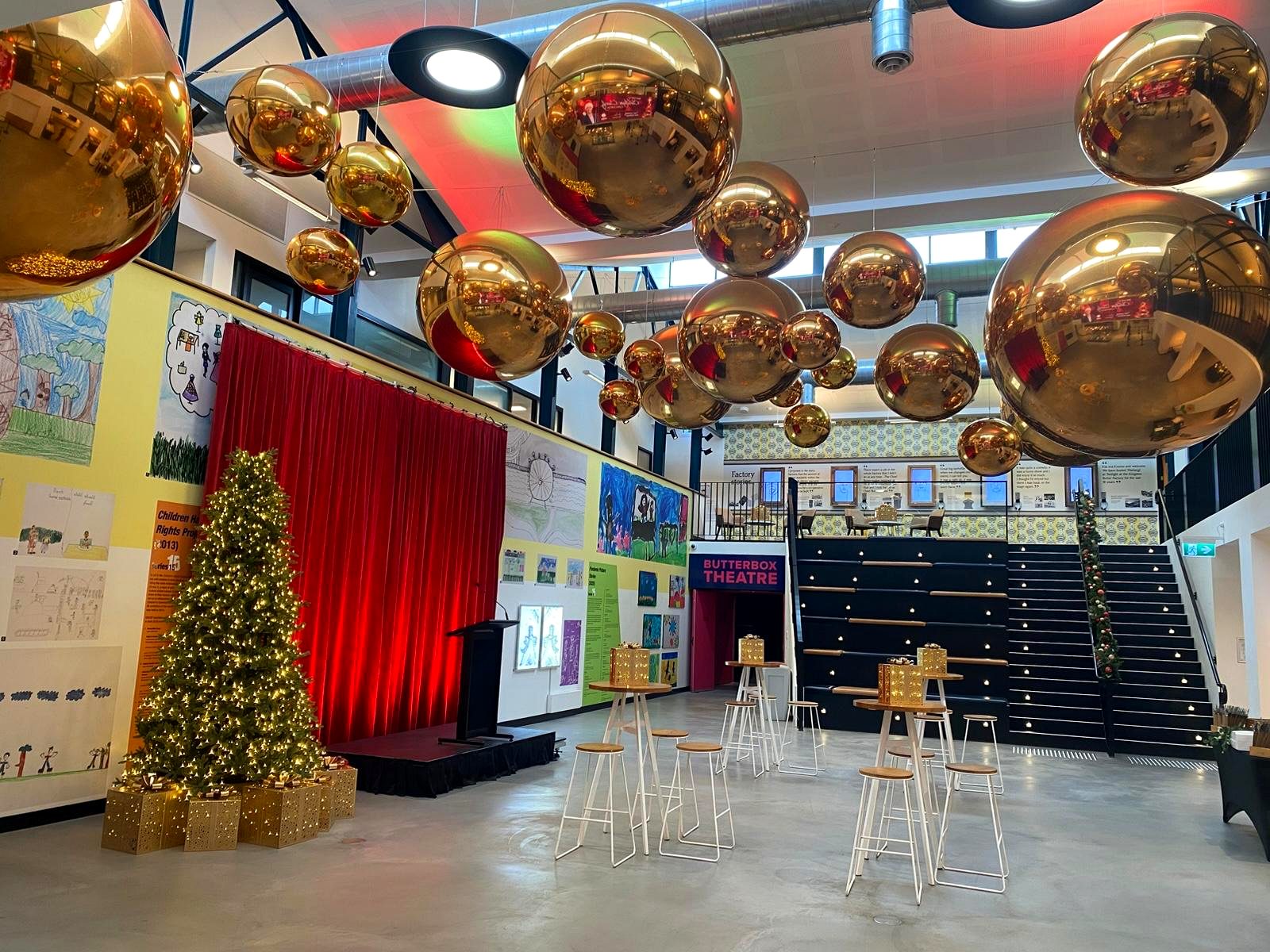 Corporate Christmas party venue with oversized gold bauble installation