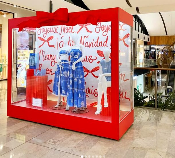 Oversized gift box window display with festive typography