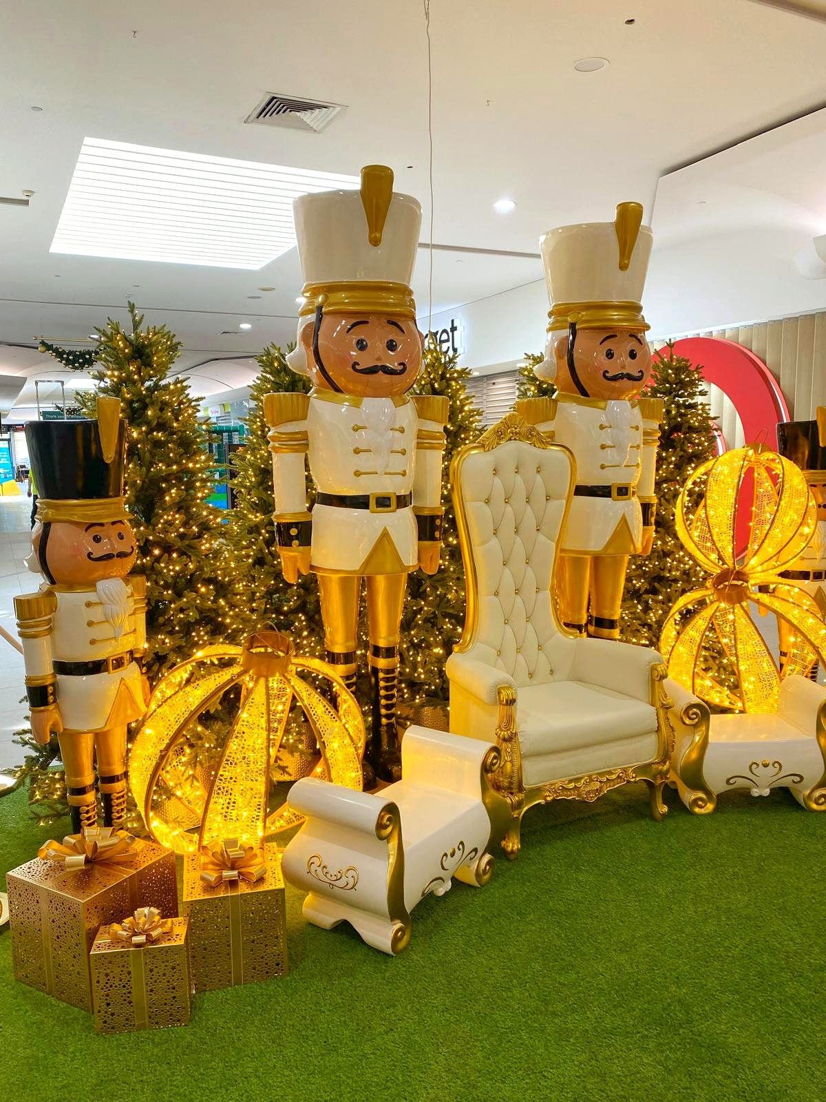 Nutcracker soldiers beside a white and gold Santa throne Christmas display