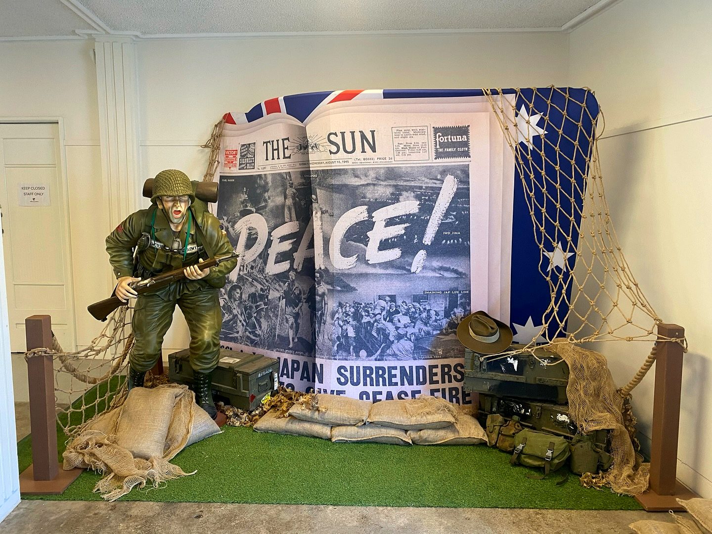 Victory in the Pacific commemorative display with soldier figure and newspaper backdrop